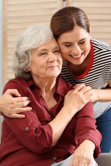 Dos mujeres abrazándose con mucho cariño y sonriendo