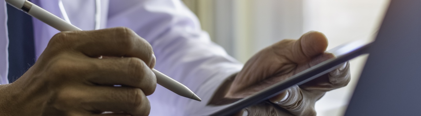 Manos usando una tableta con un lapicero táctil