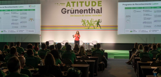 Mujer exponiendo en un evento de Grünenthal con mucho público